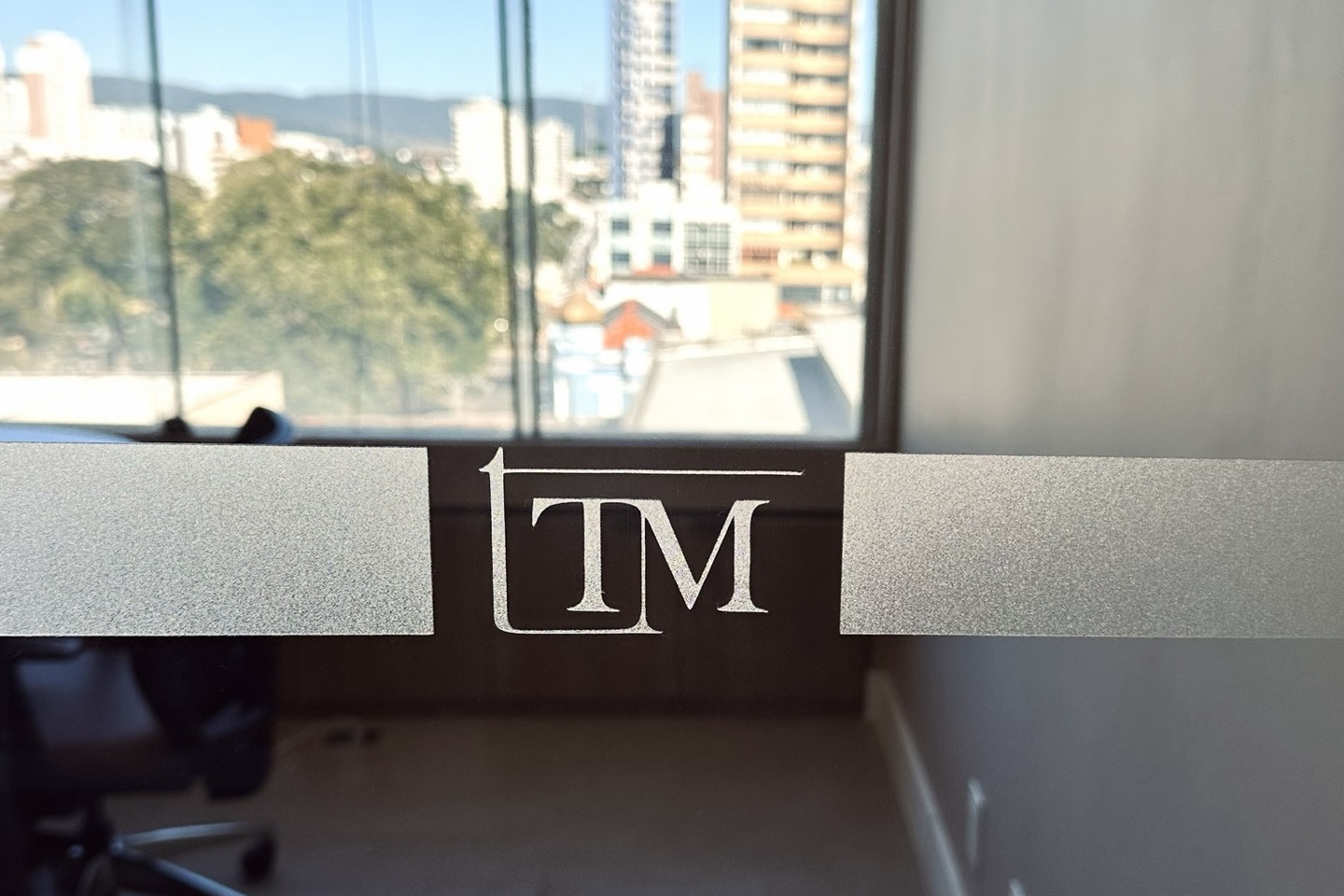 Logo da Tognetti Moreto Advocacia jateado na divisória de vidro do escritório